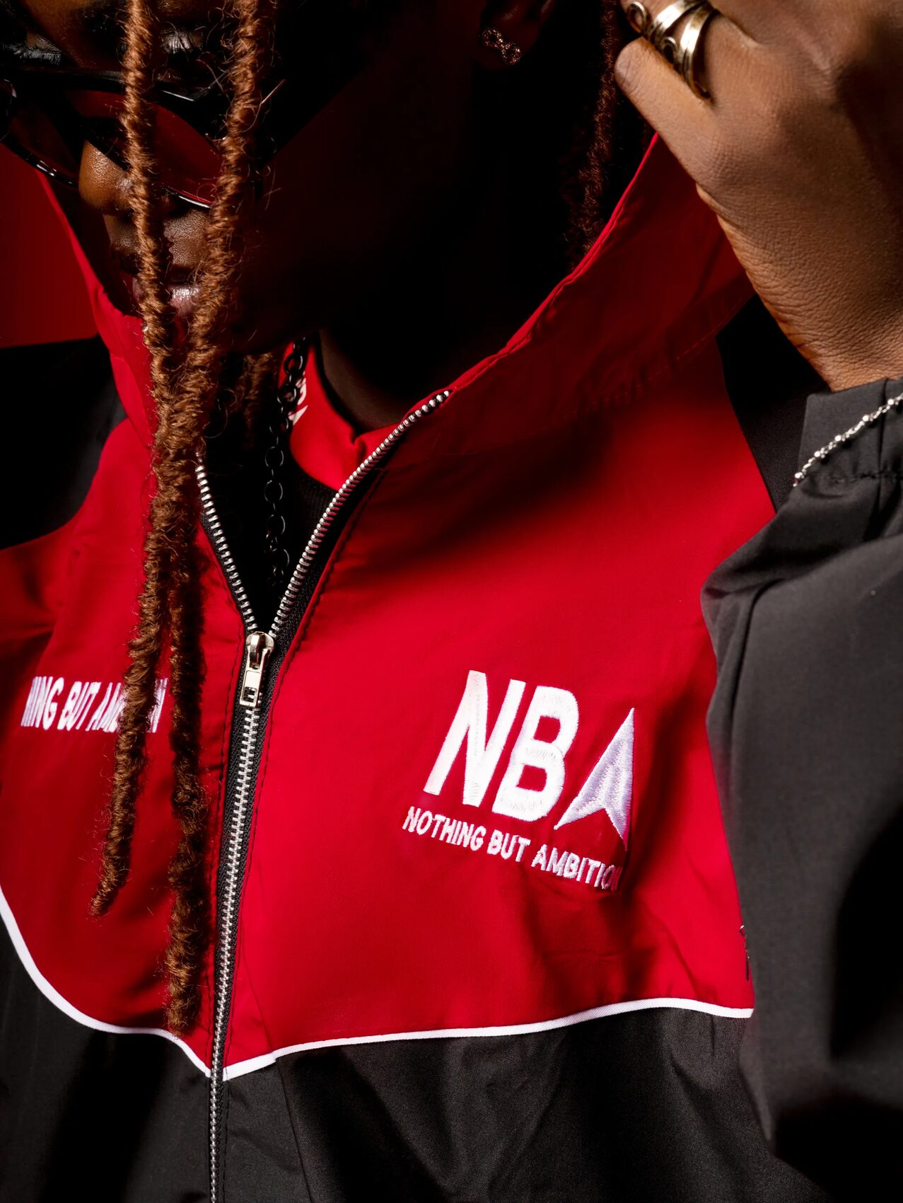 Close-up detail of the embroidered NBA logo on the tracksuit jacket