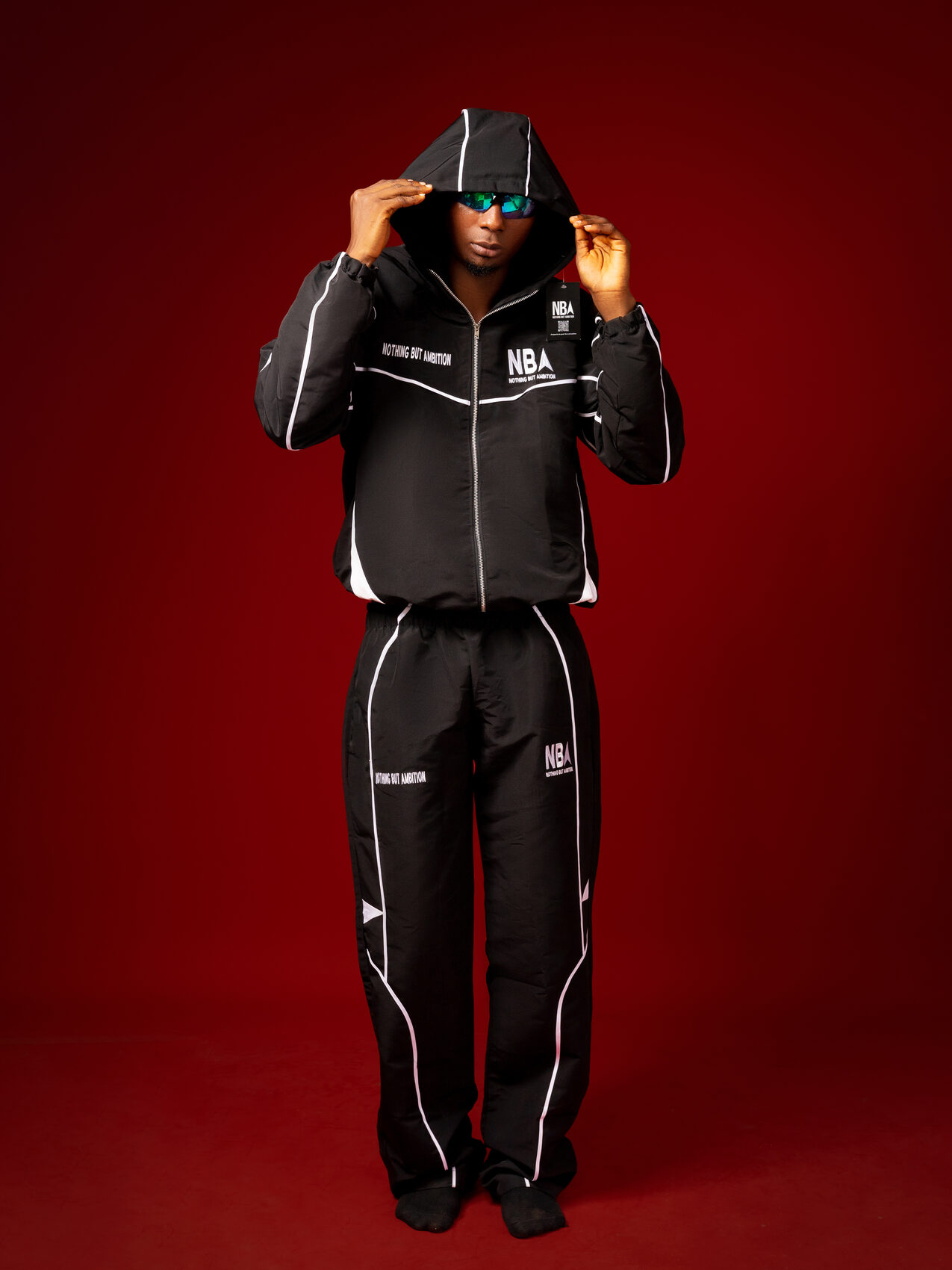 Model wearing the black NBA tracksuit with the hood up, studio shot
